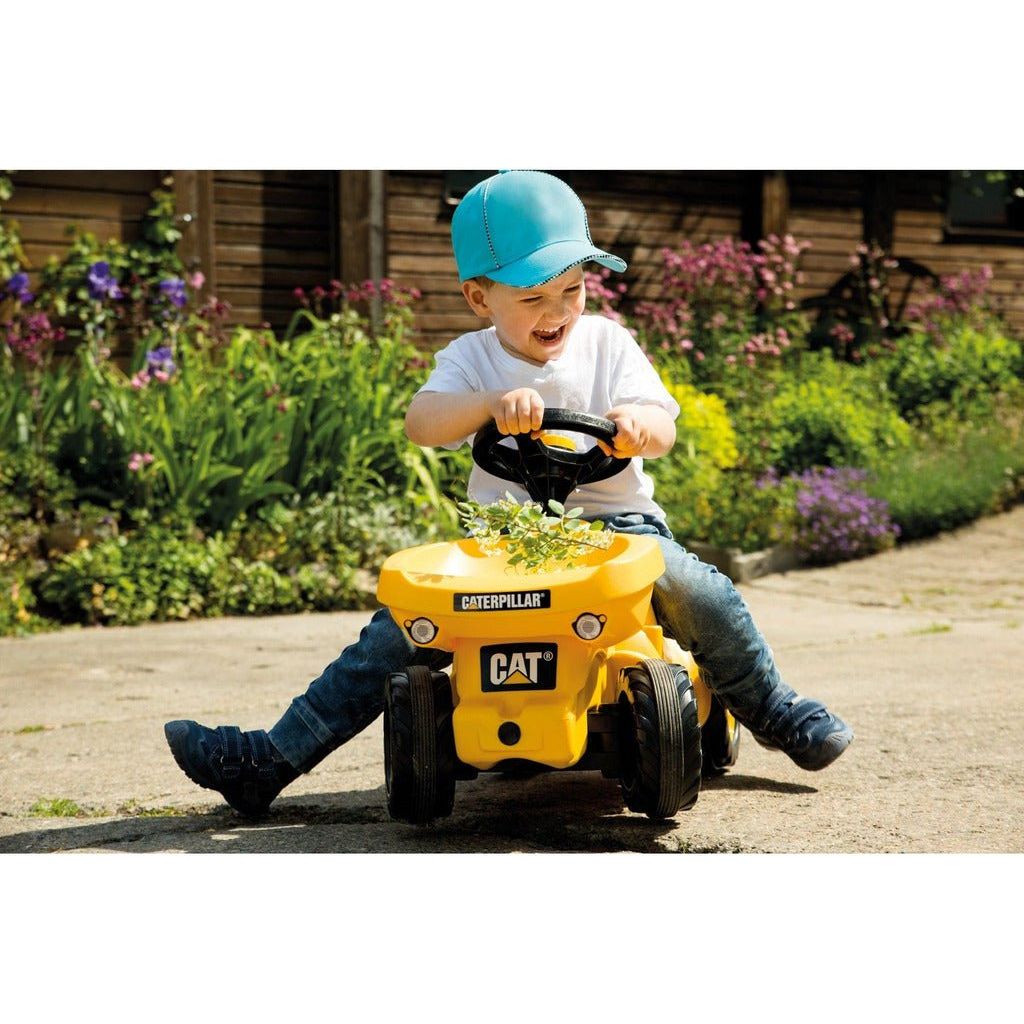 smiling boy riding Rolly Toys Caterpillar Dumper Mini Trac With Tipping Dumper