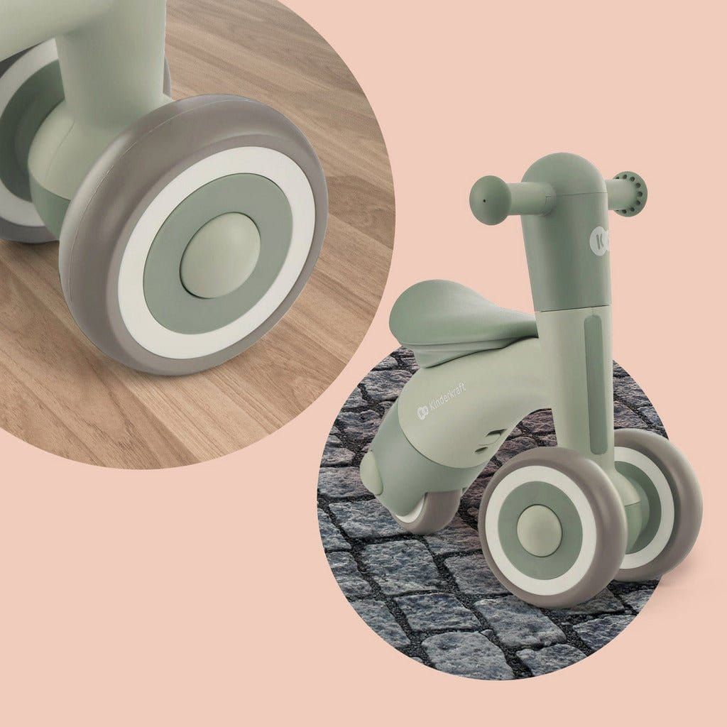 Green Kinderkraft Minibi Tricycle indoors and outdoors