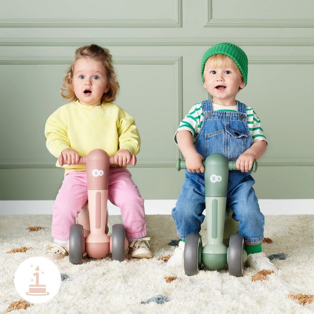 boy and girl sitting on Pink Kinderkraft Minibi Tricycle side by side