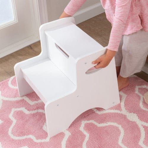 girl picking up KidKraft Two-Step Stool - White by handles