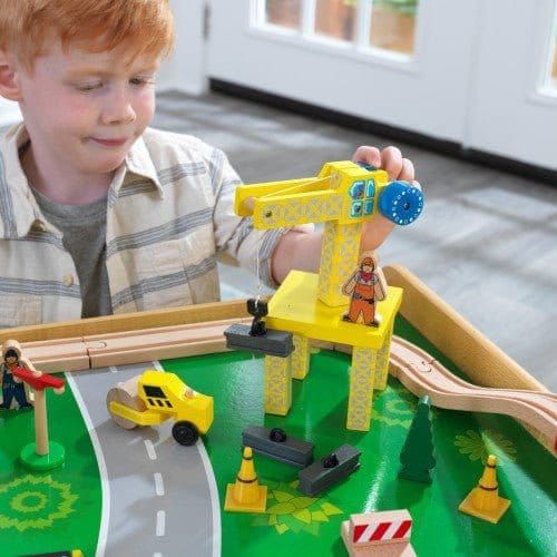 boy playing with crane from KidKraft Waterfall Mountain Train Set & Table