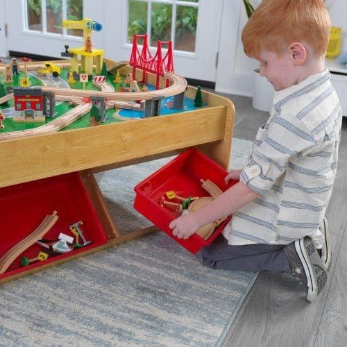 boy lifting storage container from KidKraft Waterfall Mountain Train Set & Table
