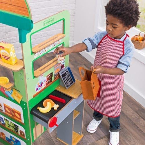 close up of girl using till of KidKraft Let’s Pretend™ Grocery Store Pop-Up
