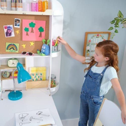 girl getting pen from shelf of KidKraft Arches Floating Wall Desk & Chair - White