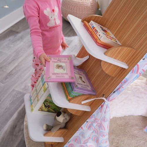 girl puttign book on shelf of KidKraft Book Nook Tent with Shelves