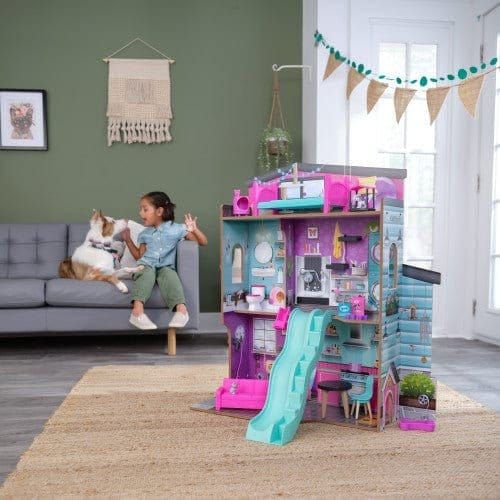 girl and dog sditting on sofa in playroom with Kidkraft Purrfect Pet Dollhouse in foreground
