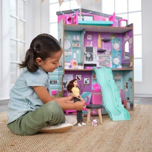girl playing with doll while sitting on rug next to Kidkraft Purrfect Pet Dollhouse