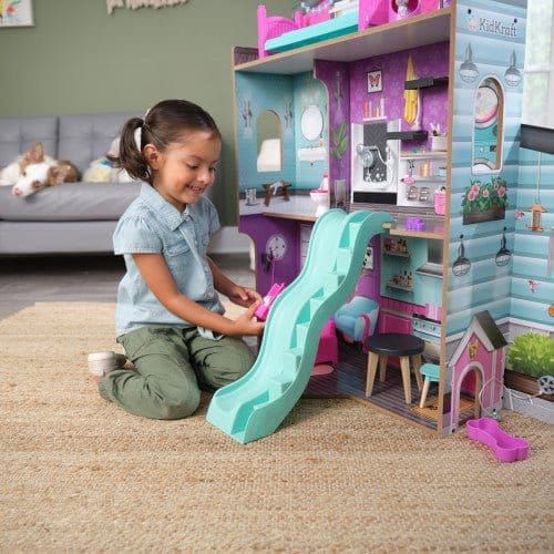 girl kneeling in front of Kidkraft Purrfect Pet Dollhouse and smiling