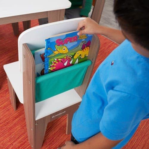 boy getting book out of storage pocket of chair