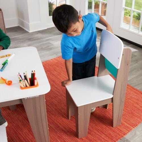 boy pulling out chair of KidKraft Pocket Storage Table and 4 Chair Set - Grey Ash