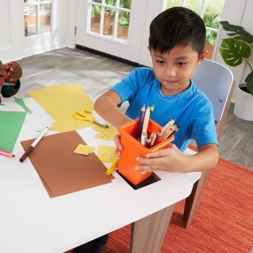 boy putting pen pot in table of KidKraft Pocket Storage Table and 4 Chair Set - Grey Ash