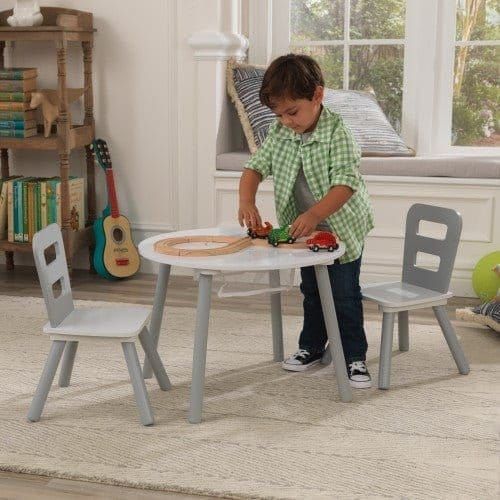boy plyaing with trains and cars on KidKraft Round Storage Table & 2 Chair Set - Grey & White