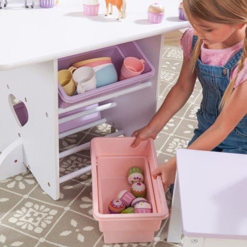 girl getting toys from storage of KidKraft Heart Table & Chair Set