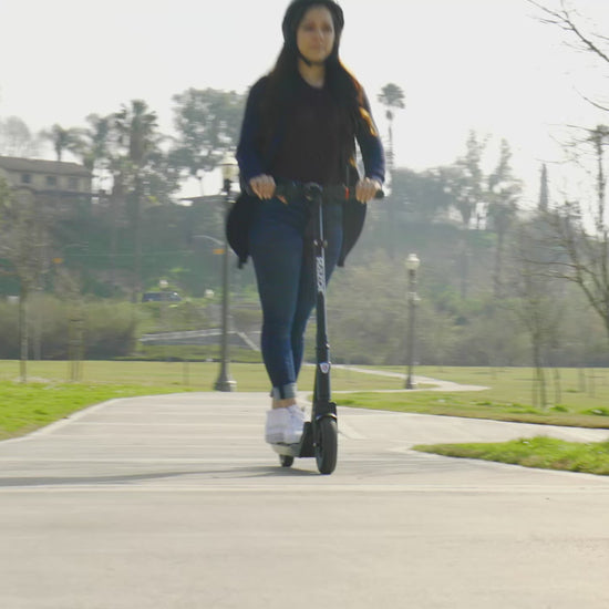 woman riding Razor E-Prime Air Electric Folding Scooter 36V on pavement