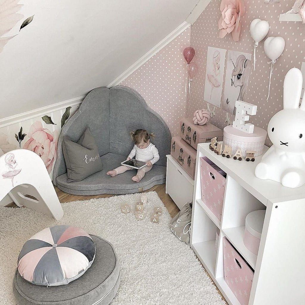girl sitting on Meow Baby Cloud Shaped Foldable Baby Play Mat in corner of room