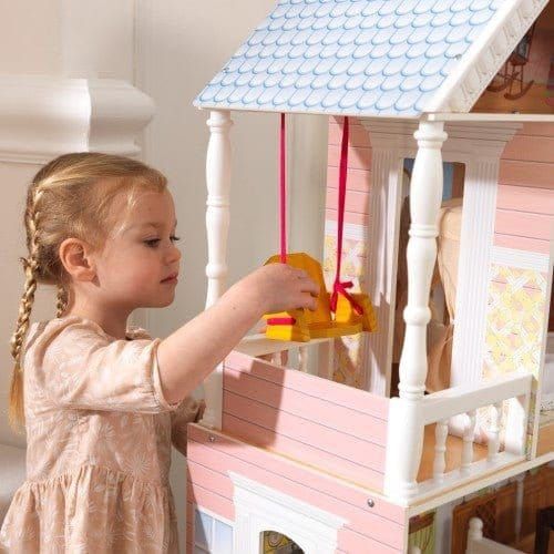 close up of girl playing with swing on balcony of KidKraft Savannah Dollhouse