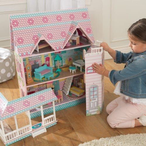 girl kneeling with KidKraft Abbey Manor Dollhouse