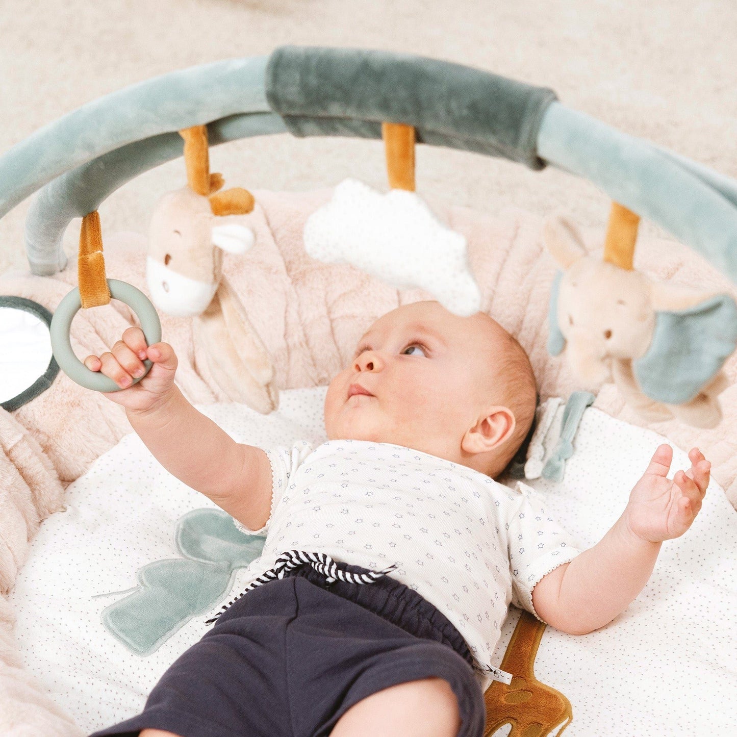 baby playing with ring on Nattou Baby Stuffed Playmat - Luna and Axel