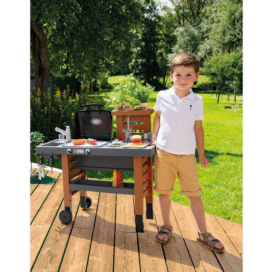 boy standing next to Smoby Garden Kitchen BBQ Set 