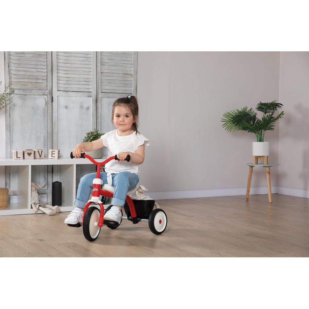 little girl riding Smoby Rookie Tricycle  inside house