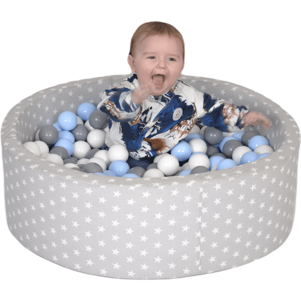 baby sitting in Misioo Cotton Ball Pit Grey and White Stars with 200 Blue & Grey Balls