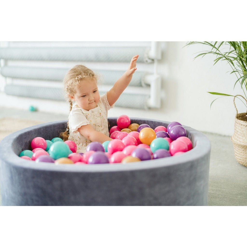 little girl sitting in Velvet Round Foam Ball Pit with 200 Balls - Steel