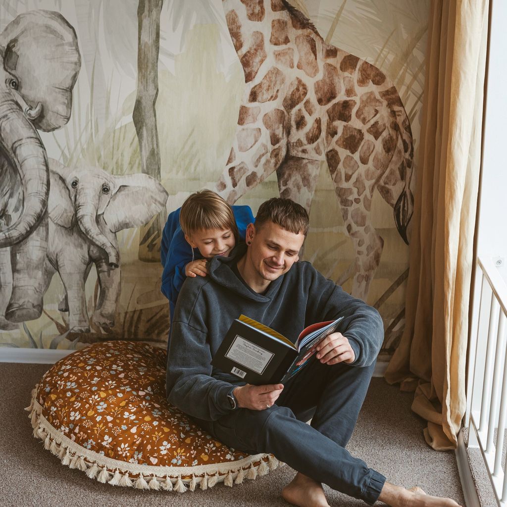 man and child sitting on MINICAMP Kids Floor Cushion Seating Pouffe in Plant Pattern reading book