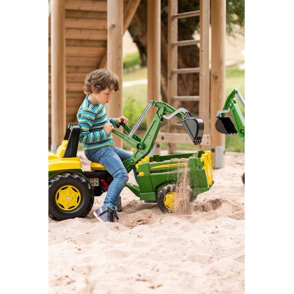 boy sitting on Rolly Toys John Deere Tractor With Frontloader & Rear Excavator in sandpit