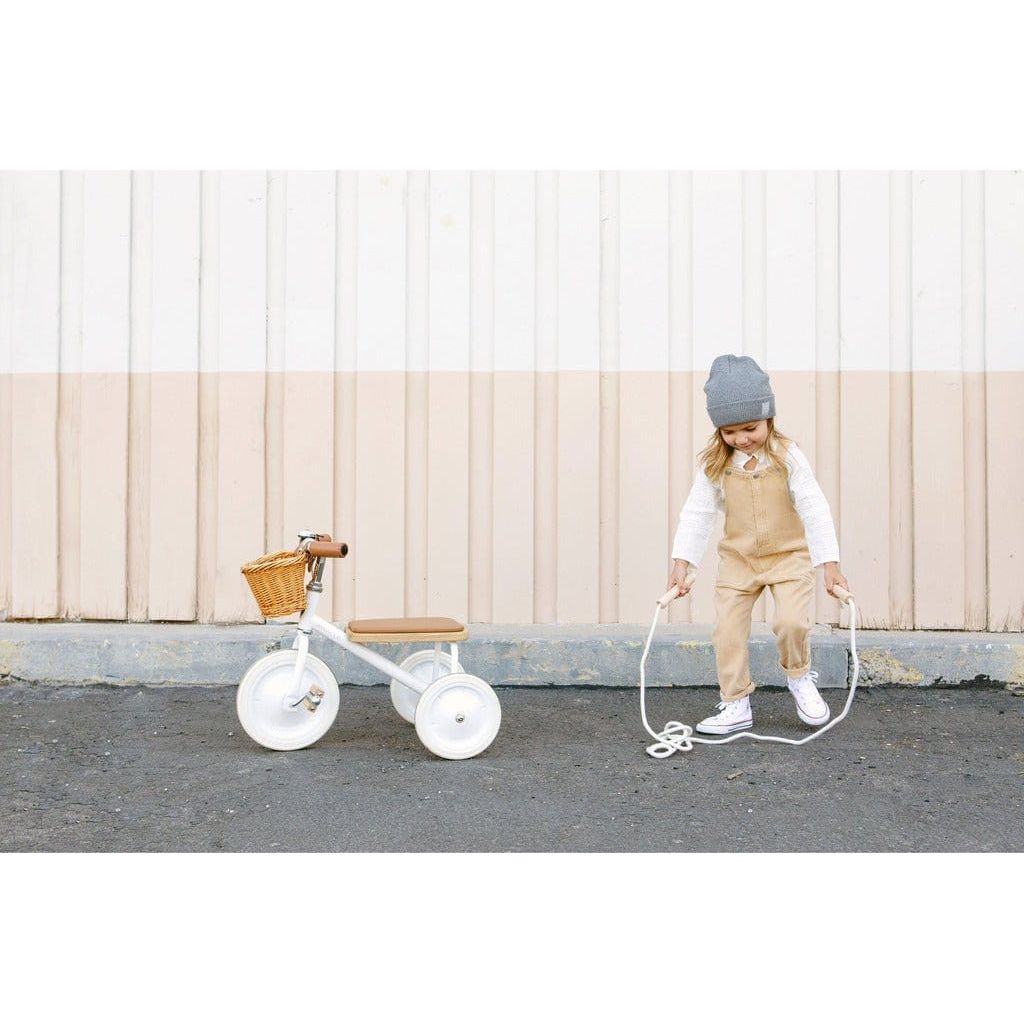Little girl skipping next to Banwood Trike Age 2+ in White