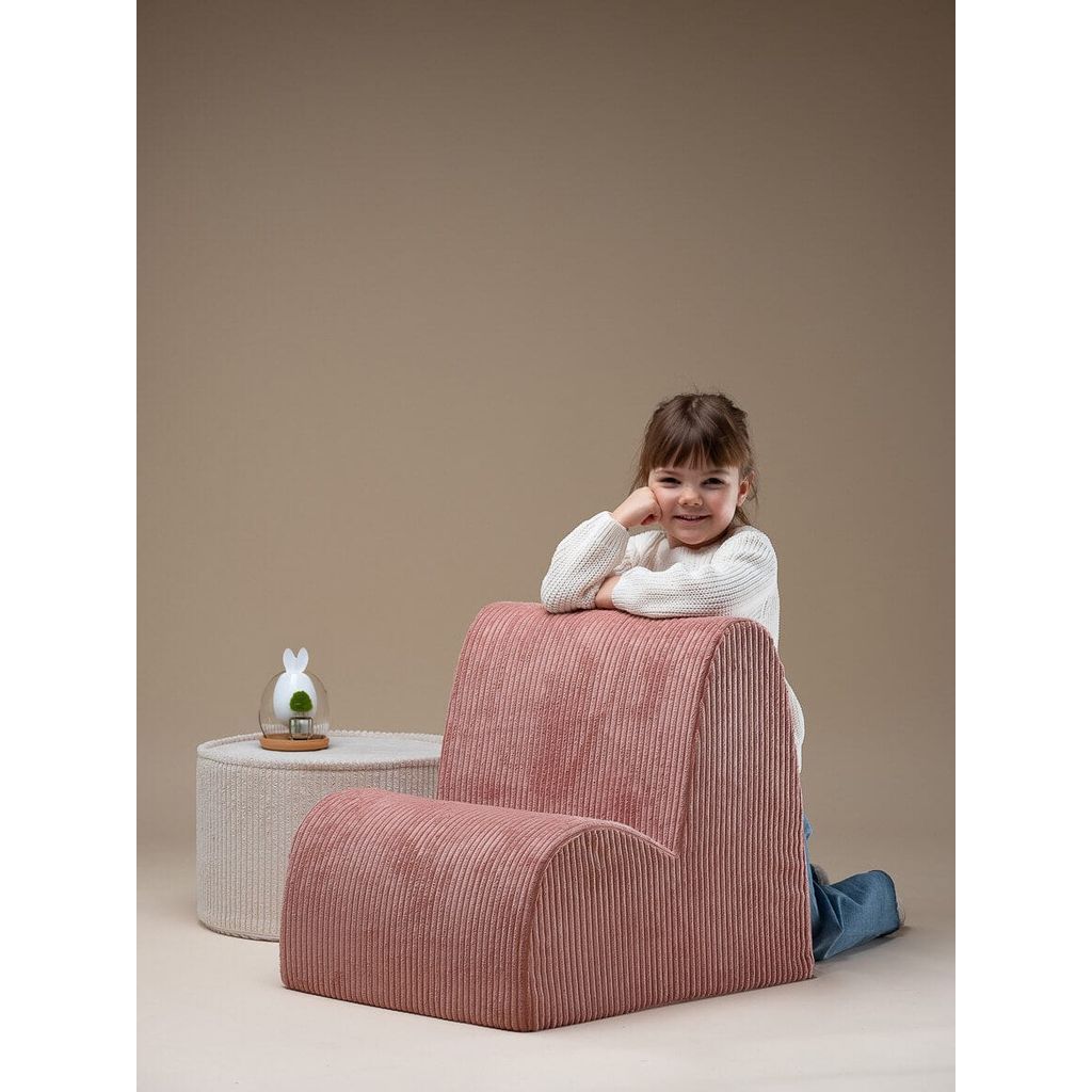 girl leaning on back of Wigiwama Pink Mousse Kids Cloud Chair