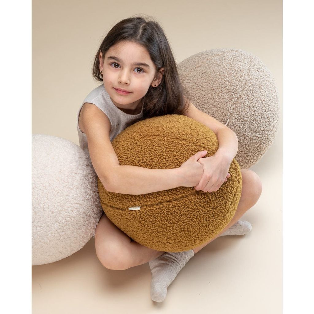 girl holding Wigiwama Maple Ball Cushion