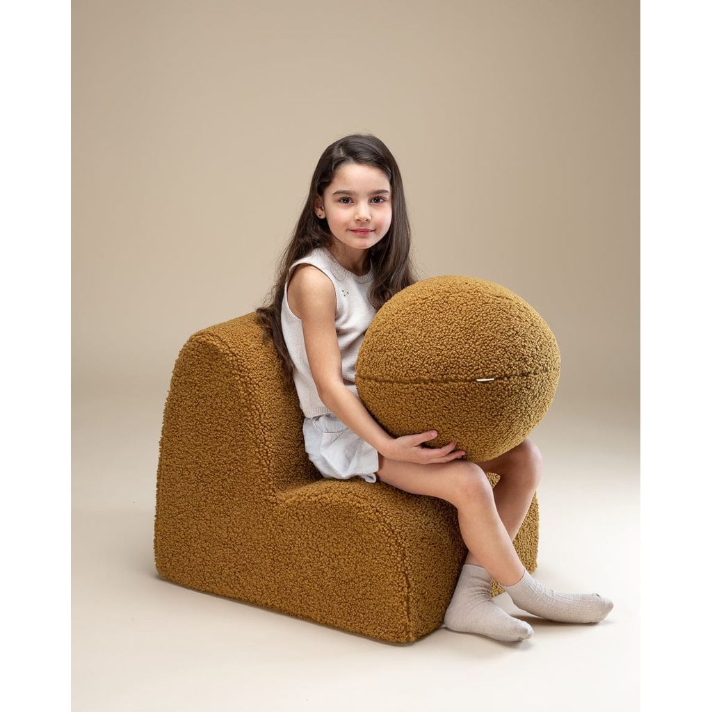 girl sitting on Wigiwama Maple Cloud Chair holding ball cushion