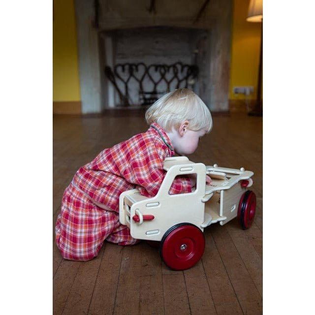 child playing with natural wood colour Moover dump truck ride on