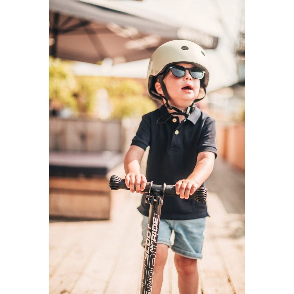 little boy in sunglasses riding scooter and wearing Scoot and Ride Helmet Ash - S-M