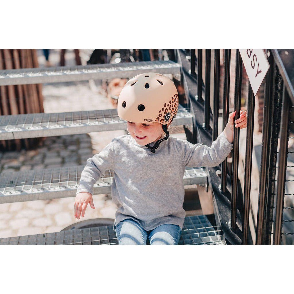 little girl sitting on stairs wearing Scoot and Ride Helmet - XXS - S - Leopard