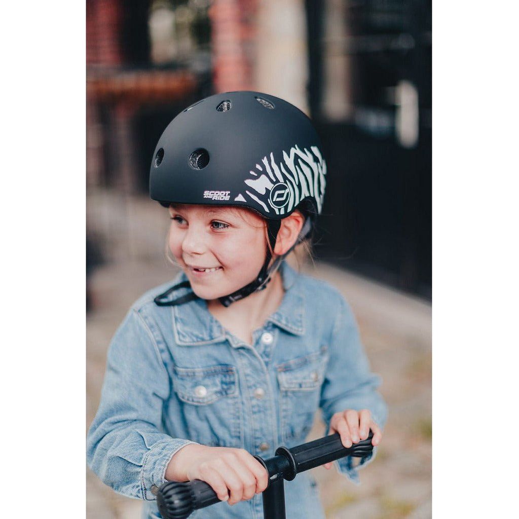 little girl riding highwaykick 1 wearing Scoot and Ride Helmet - XXS - S - Zebra