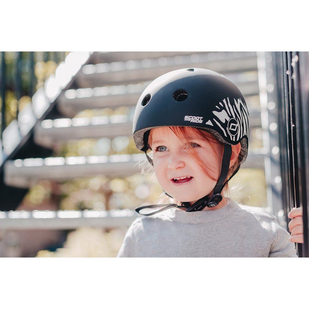 little girl on stairs wearing Scoot and Ride Helmet - XXS - S - Zebra