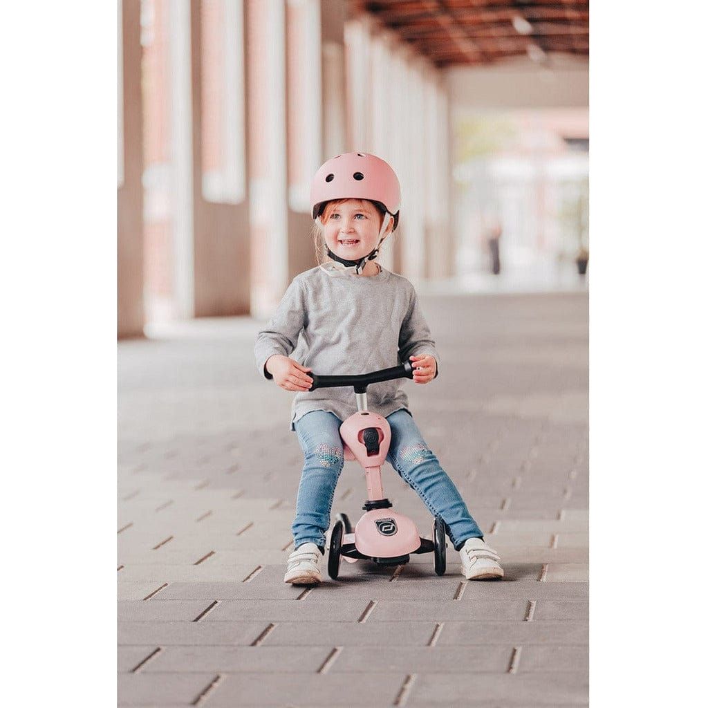 smiling girl sitting on Scoot and Ride Highwaykick 1  Scooter - Rose - Age 1-5 Years