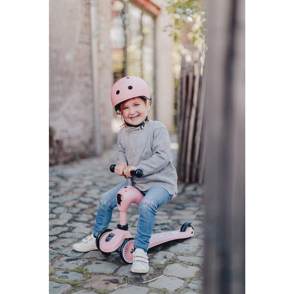 little girl on cobbled street sitting on Scoot and Ride Highwaykick 1  Scooter - Rose - Age 1-5 Years
