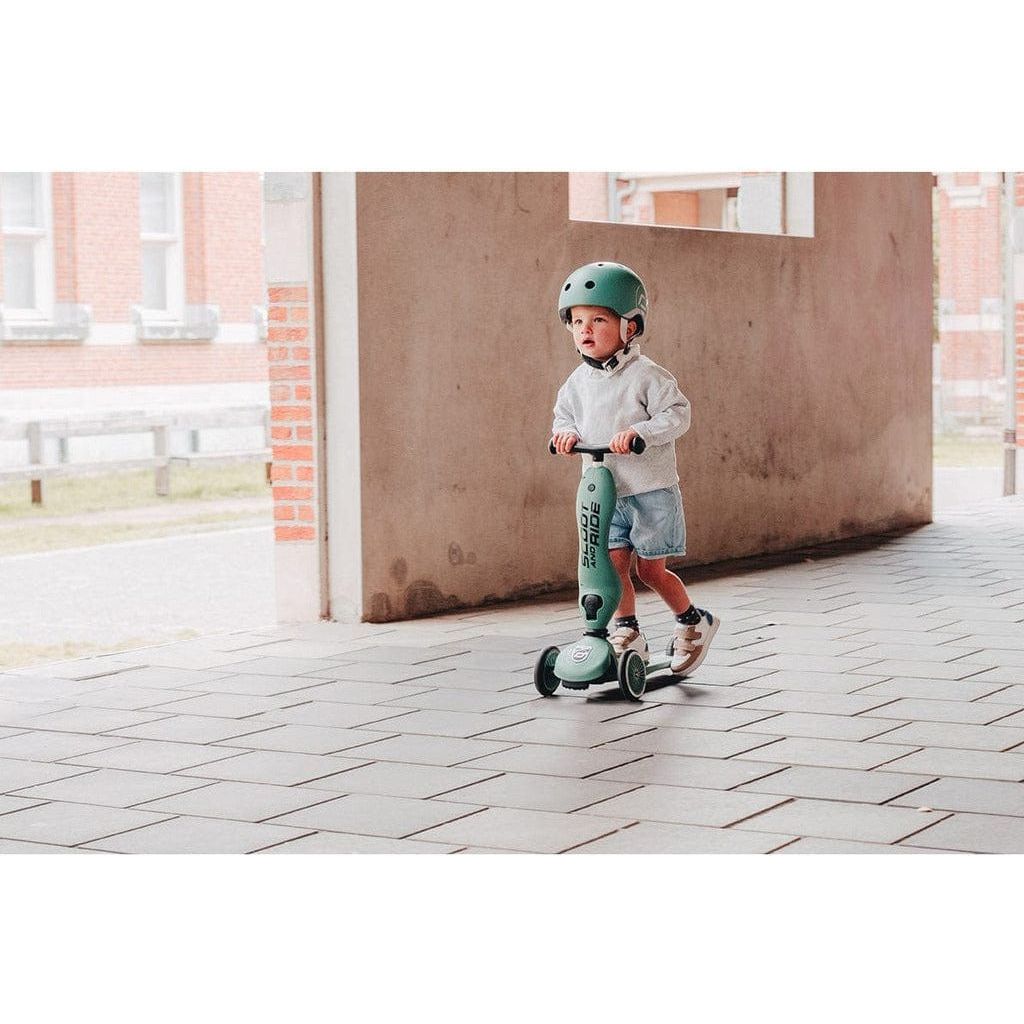 little boy in Green helmet riding Scoot and Ride Highwaykick 1 - Forest - Age 1-5 Years