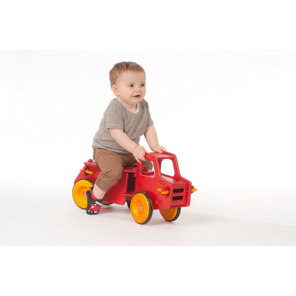 boy sitting on Moover Wooden Ride On Dump Truck - 8 Months+ - Red