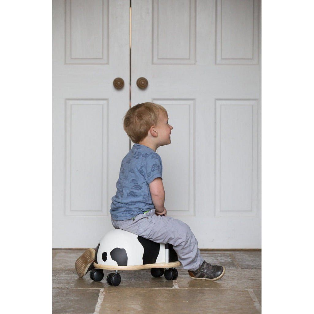 little boy sitting on Wheelybug Ride On - Cow