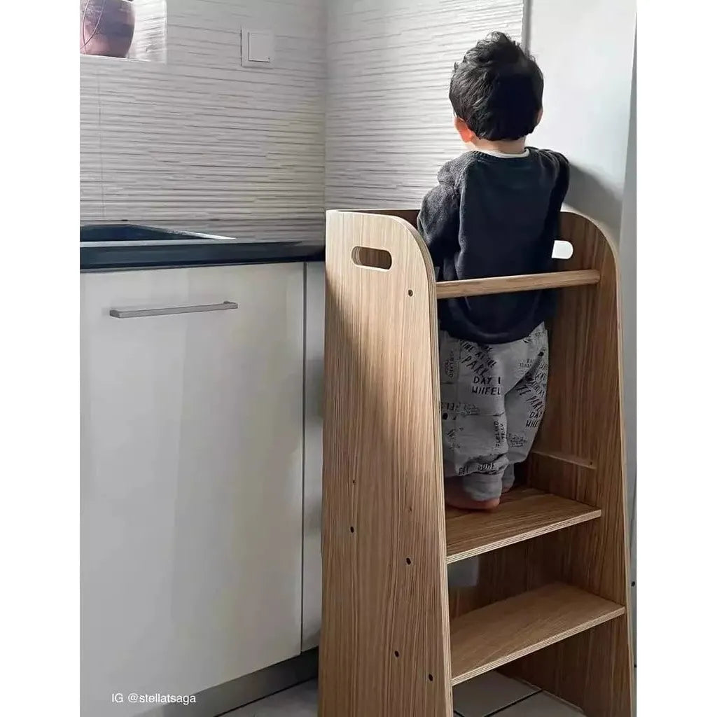 boy standing on Curve Lab Learning Curve Learning Tower in kitchen