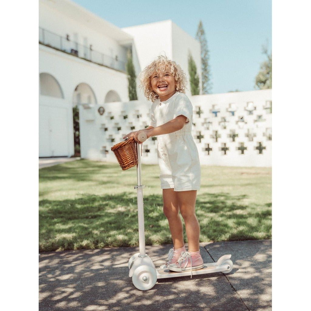 Child riding Banwood Scooter Age 3+ in White with wicker basket