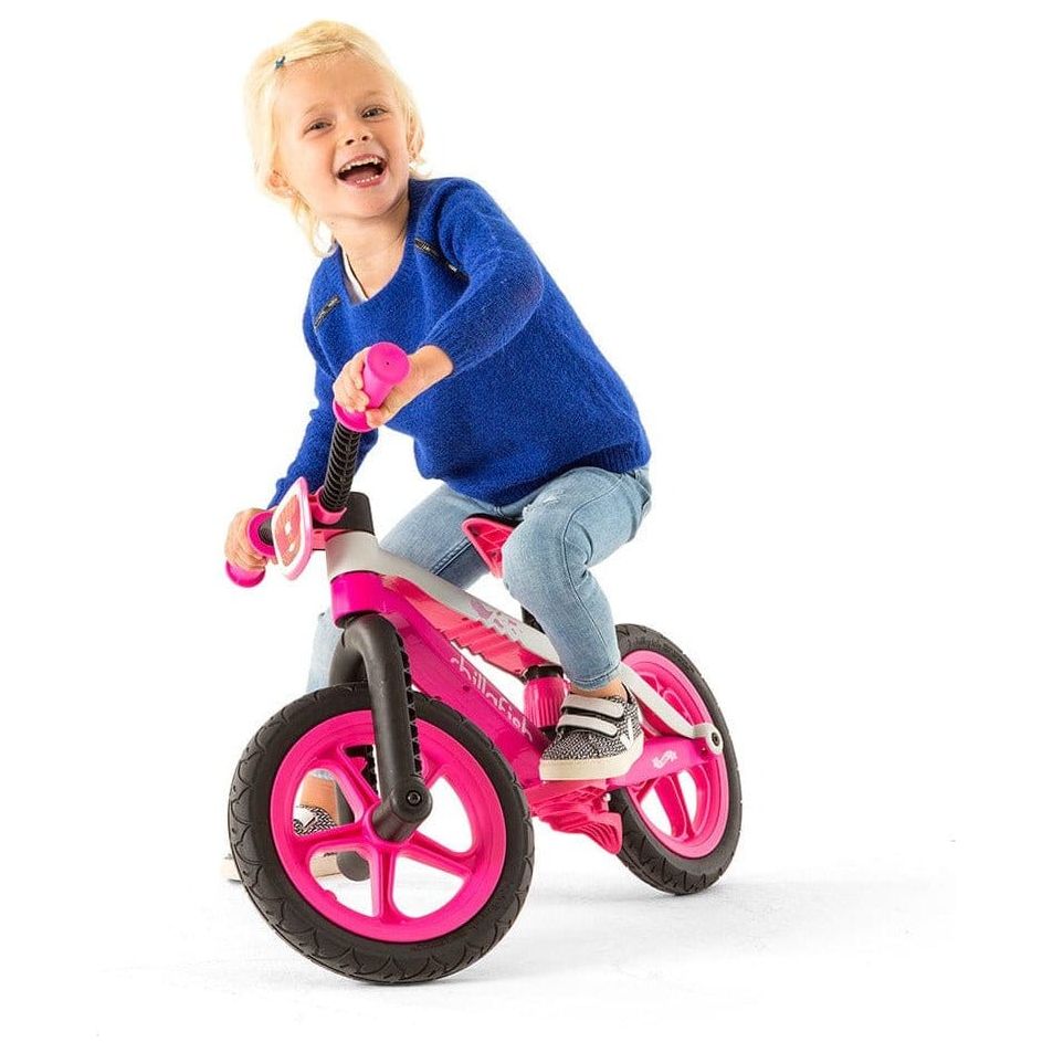 smiling child riding Chillafish Bmxie Balance Bike 2-5 Years in Pink