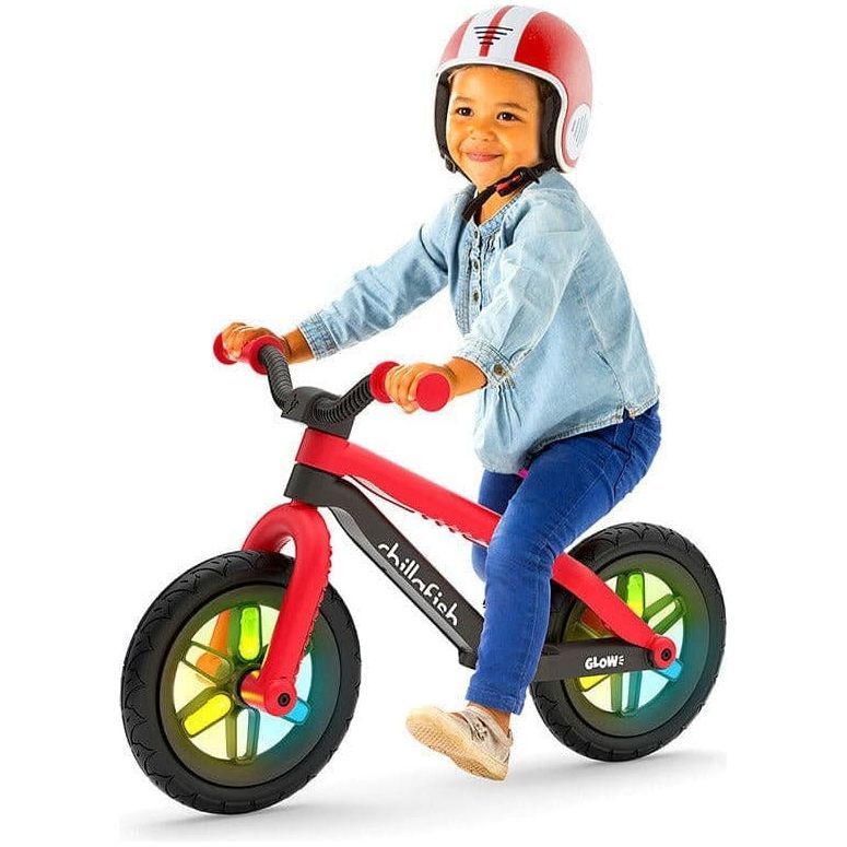 Little boy riding Chillafish Bmxie Glow Balance Bike 2-5 Years in Red and wearing helmet