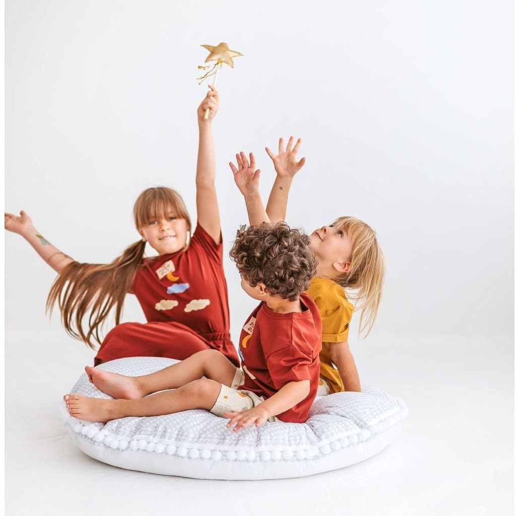 three children sitting on MINICAMP Big Floor Cushion Rhombus Diamond - Grey with arms in the air