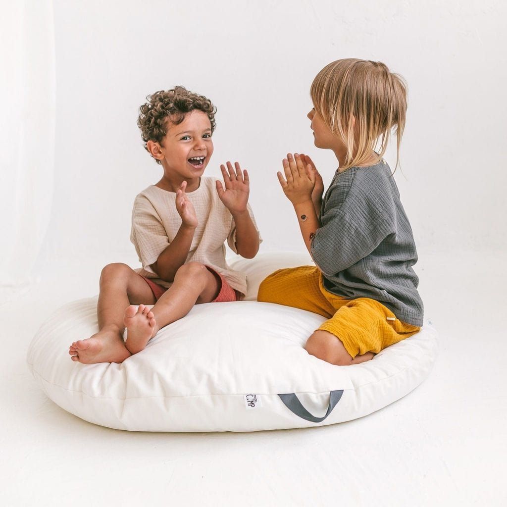 smiling boy and girl sitting on MINICAMP Lounger Floor Pillow With Handle