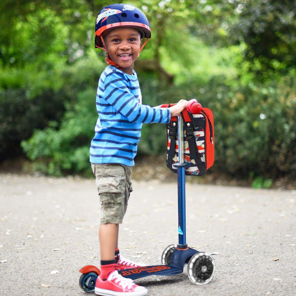 smiling boy standing with Micro Scooter Mini Deluxe LED - Navy