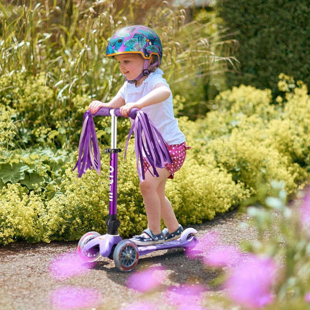 girl riding Micro Scooter Mini Foldable - LED Purple in garden